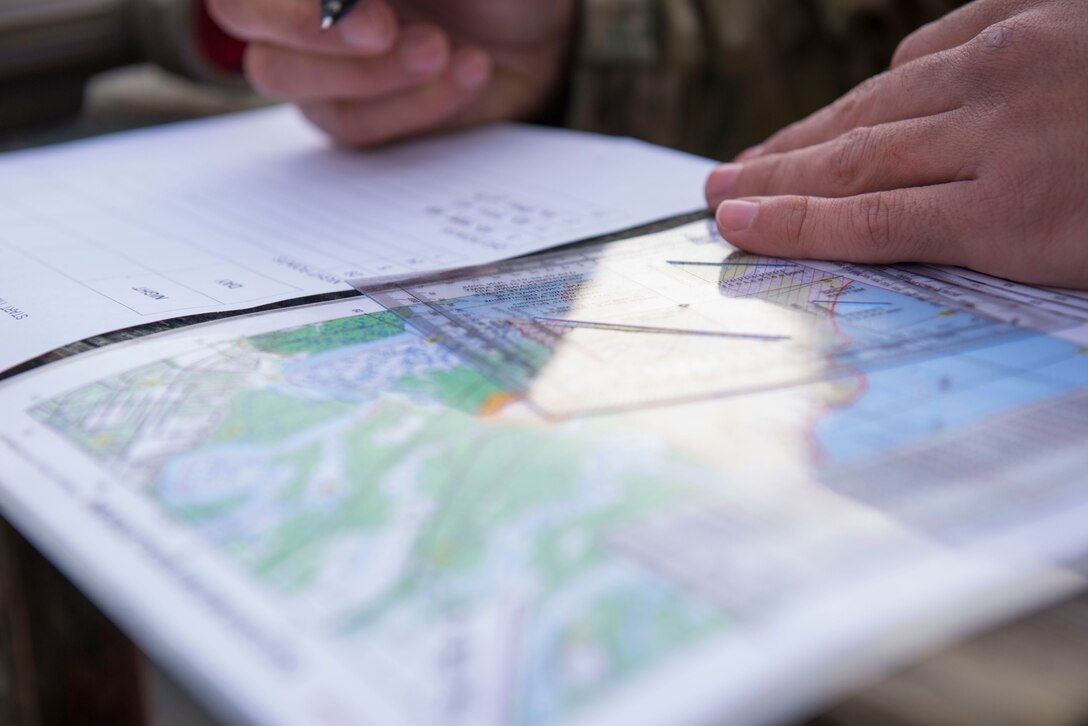 A U.S. Army Soldier plans a route for a land navigation exercise in Fort Eustis’ Training Area 23 at Joint Base Langley-Eustis, Virginia., April 11, 2018. Soldiers used a map protractor to plot coordinates then used a compass to locate each point. (U.S. Air Force photo by Airman 1st Class Monica Roybal)