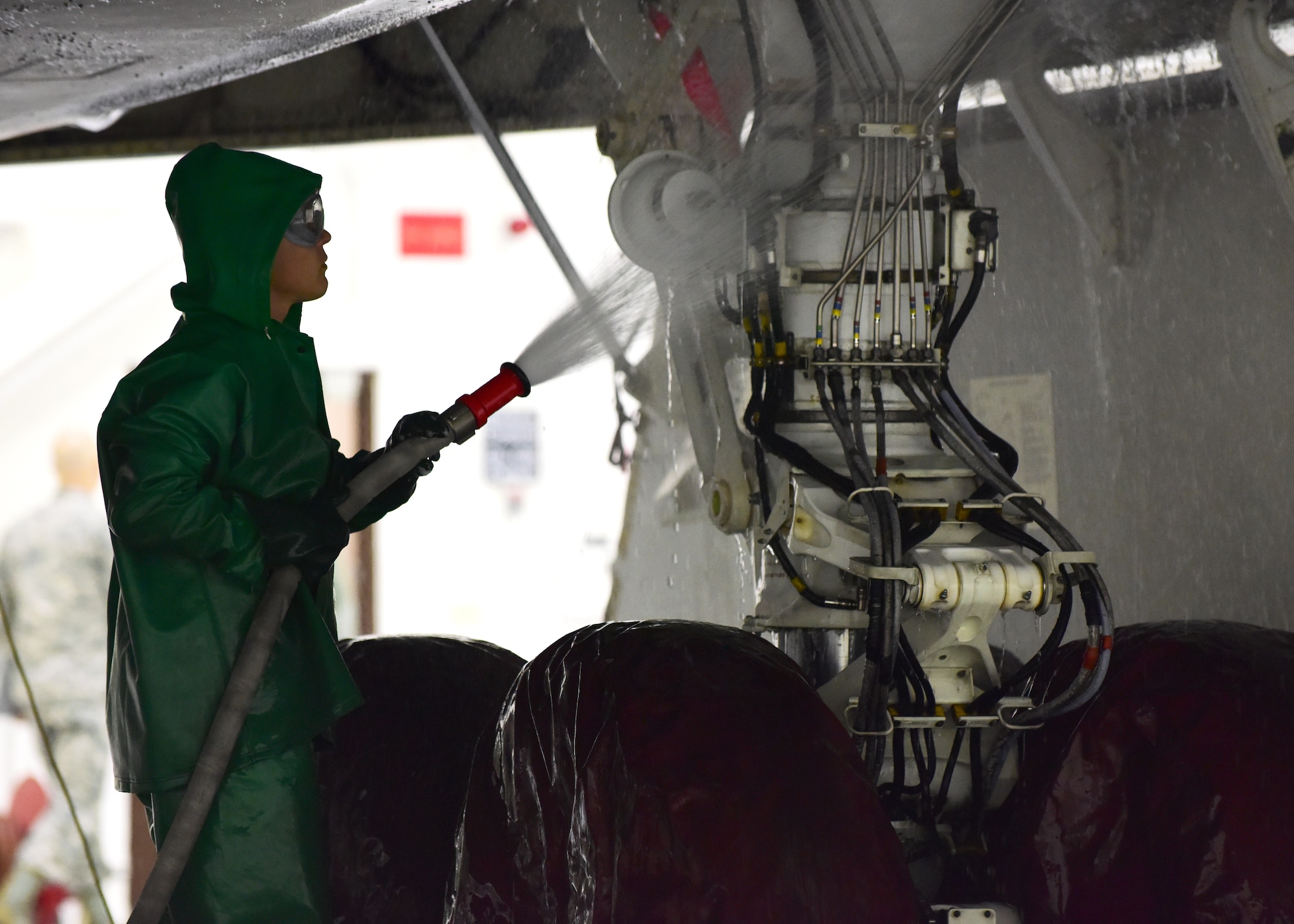 A 509th Aircraft Maintenance Squadron crew chief sprays water on the landing gear of a B-2 Spirit during a wash at Whiteman Air Force Base, Mo., April 10, 2018. It takes about three days and 10 Airmen to complete a thorough wash of one B-2. (U.S. Air Force photo by Staff Sgt. Danielle Quilla)