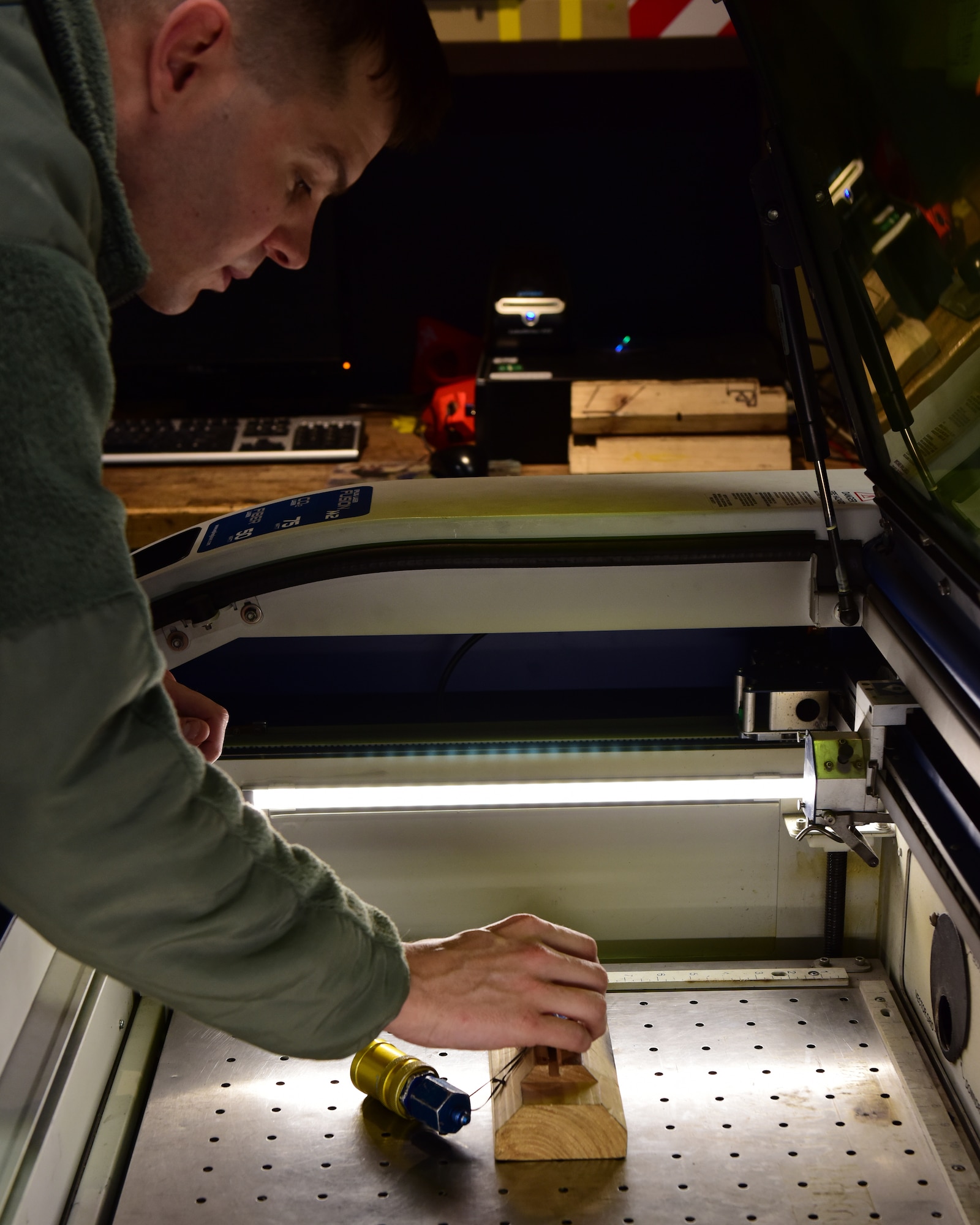 U.S. Air Force Staff Sgt. Randell White, a mobility support technician assigned to the 509th Aircraft Maintenance Squadron, places a piece of equipment in the Epilog Laser Fusion M2 to be engraved with a label at Whiteman Air Force Base, Mo., April 10, 2018. The Fusion M2 model is a dual-source laser system that allows the Airmen to perform both metal marking applications and CO2 laser applications from the same system, in the same job. (U.S. Air Force photo by Staff Sgt. Danielle Quilla)