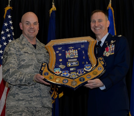 Col. James P. Ryan, retired 157th Air Refueling Wing commander, receives his shadow box from Command Chief Master Sgt. Matthew S. Heiman, the 157th ARW command chief, on April 07, 2018 at Pease Air National Guard Base, N.H. The shadow box serves as a visual representation of Ryan's career, after more than 30 years of service. (N.H. Air National Guard photo by Airman 1st Class Victoria Nelson)
