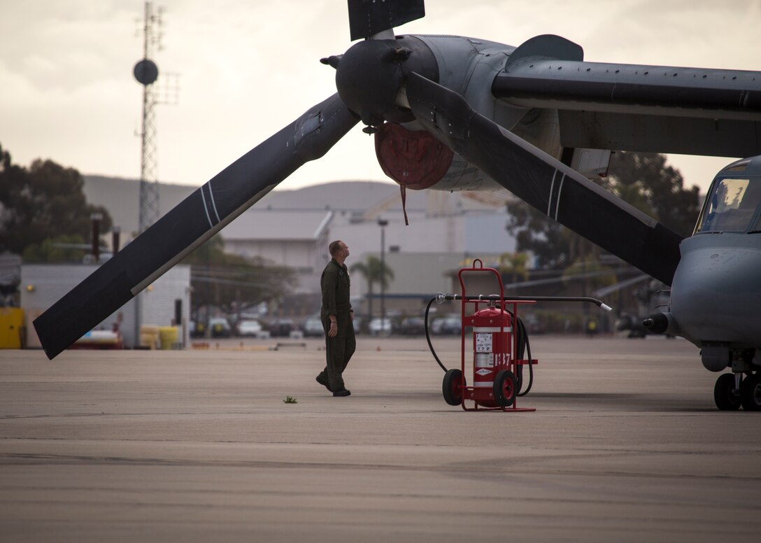 A Marine with Marine Medium Tiltrotor Squadron (VMM) 166 (Reinforced), Marine Aircraft Group 16, 3rd Marine Aircraft Wing, inspects an MV-22B Osprey on the flight line at Marine Corps Air Station Miramar, Calif., April 12. Marine Heavy Helicopter Squadron (HMH) 361, Marine Light Attack Helicopter Squadron (HMLA) 469 and VMM-166 consolidated to become VMM-166 (Rein) for an upcoming combat deployment with the 13th Marine Expeditionary Unit. MCAS Miramar is home to 3rd MAW and 19 of its squadrons. (U.S. Marine Corps photo by Cpl. Becky Calhoun/Released)