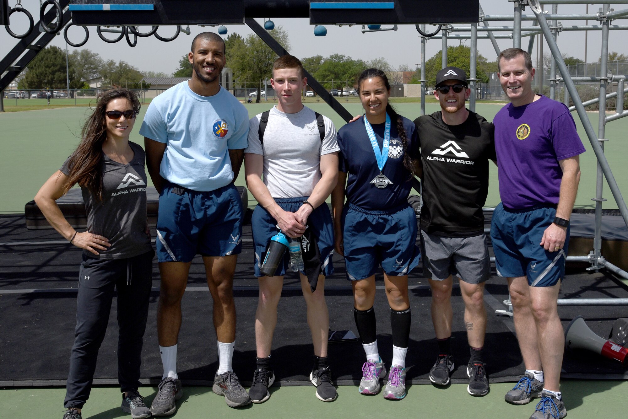 Rebekah Bonilla celebrity athlete, Airman 1st Class DeVontee Lawson, 316th Training Squadron trainee, Amn. Jonah Chose, 316th TRS trainee, Airman 1st Class Christiana Bardsley, 315th TRS trainee, Kevin Klein celebrity athlete and U.S. Air Force Col. Jeffrey Sorrell, 17th Training Wing vice commander stand together at the presentation of awards following the Alpha Warrior competition portion of Sports Day on Goodfellow Air Force base, Texas, April 13, 2018. Bardsley placed 1st, Chose 2nd and Lawson 3rd.