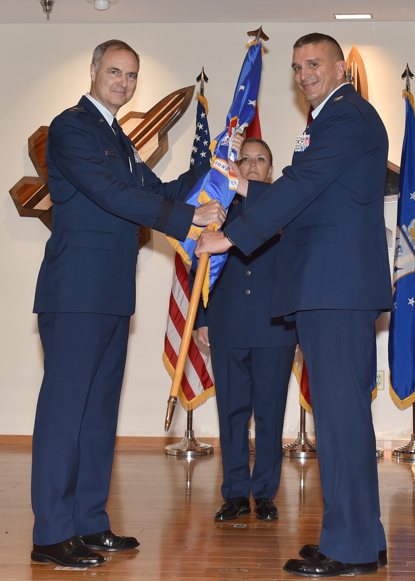 Col. Michael Valle, 101st Air and Space Operations Group commander, takes the ceremonial flag from Lt. Gen. R. Scott Williams, Continental U.S. NORAD Region – First Air Force (Air Forces Northern) commander, during the 601st Air Operations Center change of command ceremony at Tyndall Air Force Base, Florida on April 13, 2018.