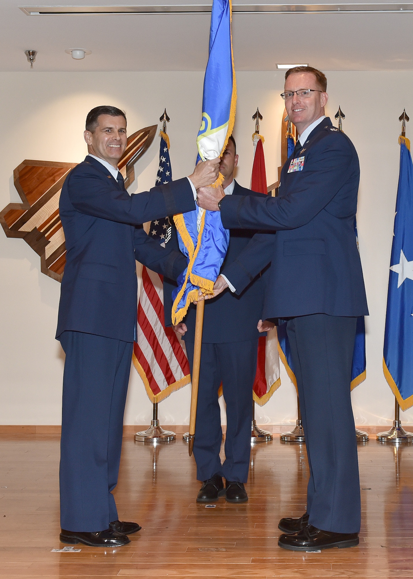 Col. Greg Krane, Continental U.S. NORAD Region – First Air Force (Air Forces Northern) deputy chief of staff, takes the ceremonial flag from Brig. Gen. Brian Simpler, Florida Air National Guard commander, during the 101st Air and Space Operations Group change of command ceremony at Tyndall Air Force Base, Florida on April 13, 2018.