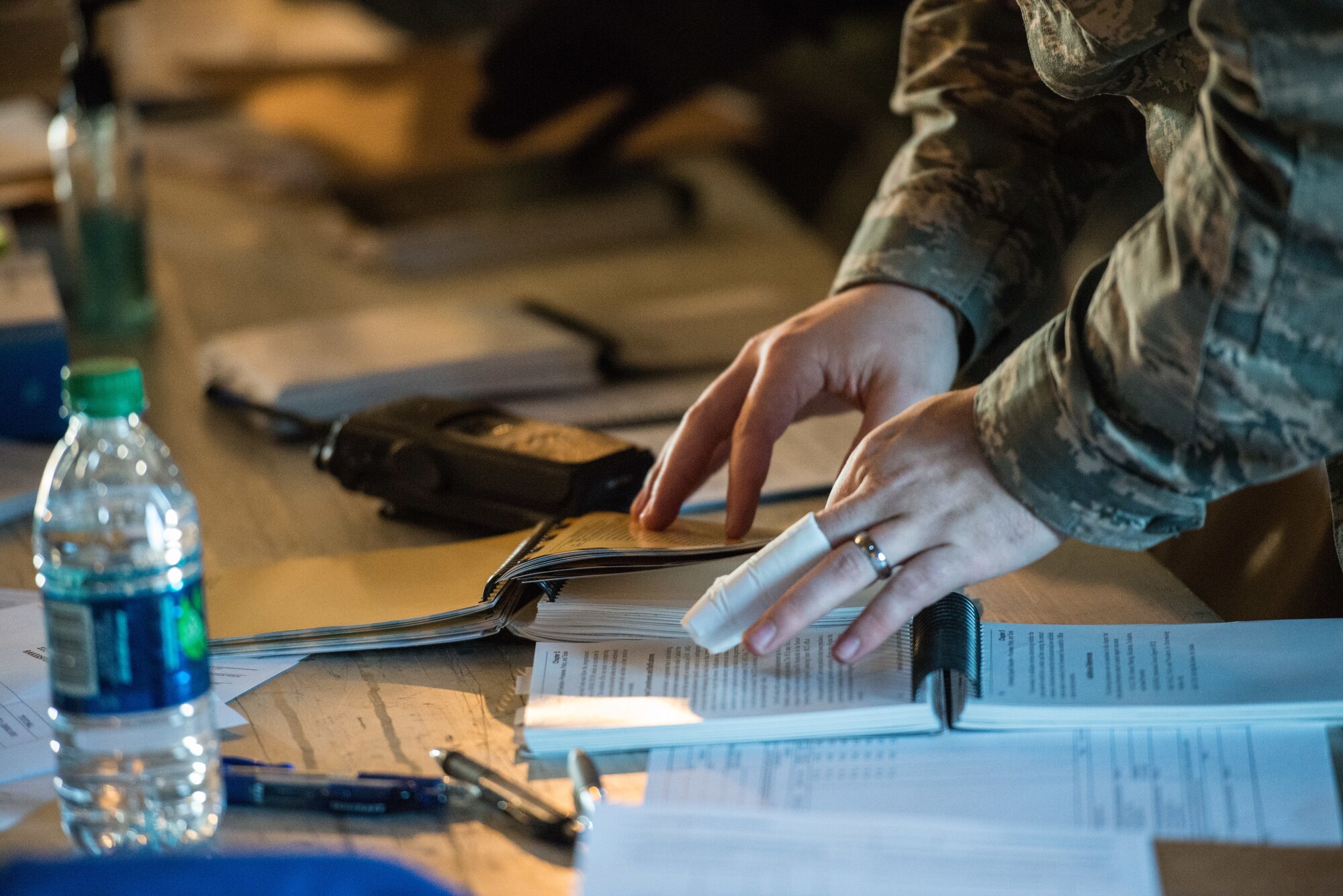 An Airman from the 56th Contracting Squadron reviews the Air Force Manual 10-100 Airman’s Manual during an exercise Feb. 23, 2018, at Luke Air Force Base, Ariz. The Airman’s Manual is a pocket-sized, quick reference guide containing Air Force instructions, visual aids and operational guidelines. (U.S. Air Force photo by Airman 1st Class Caleb Worpel)