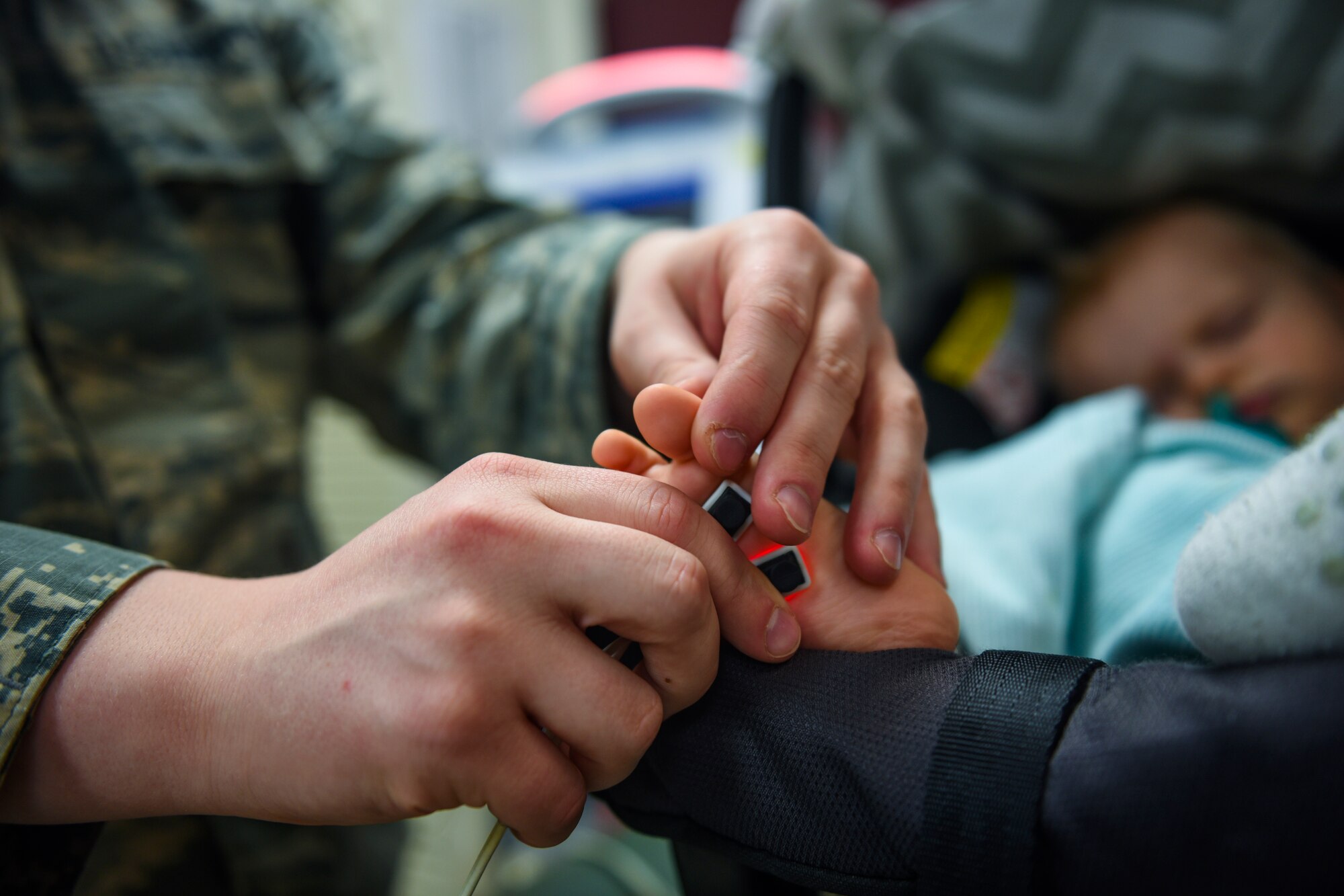 Airman 1st Class Levi Brown, 92nd Medical Group aerospace medical technician, monitors the oxygen saturation of a patient’s blood during a check-up April 4, 2018, at Fairchild Air Force Base, Washington. The pediatric team has implemented a new concept of operations: rewarding, efficiency, setting priorities and empowering team members, or RESET, to their system of patient care. The integration of RESET in the Military Health System Genesis workflow has improved the clinic’s goals of patient access and care. (U.S. Air Force photo/Airman 1st Class Whitney Laine)