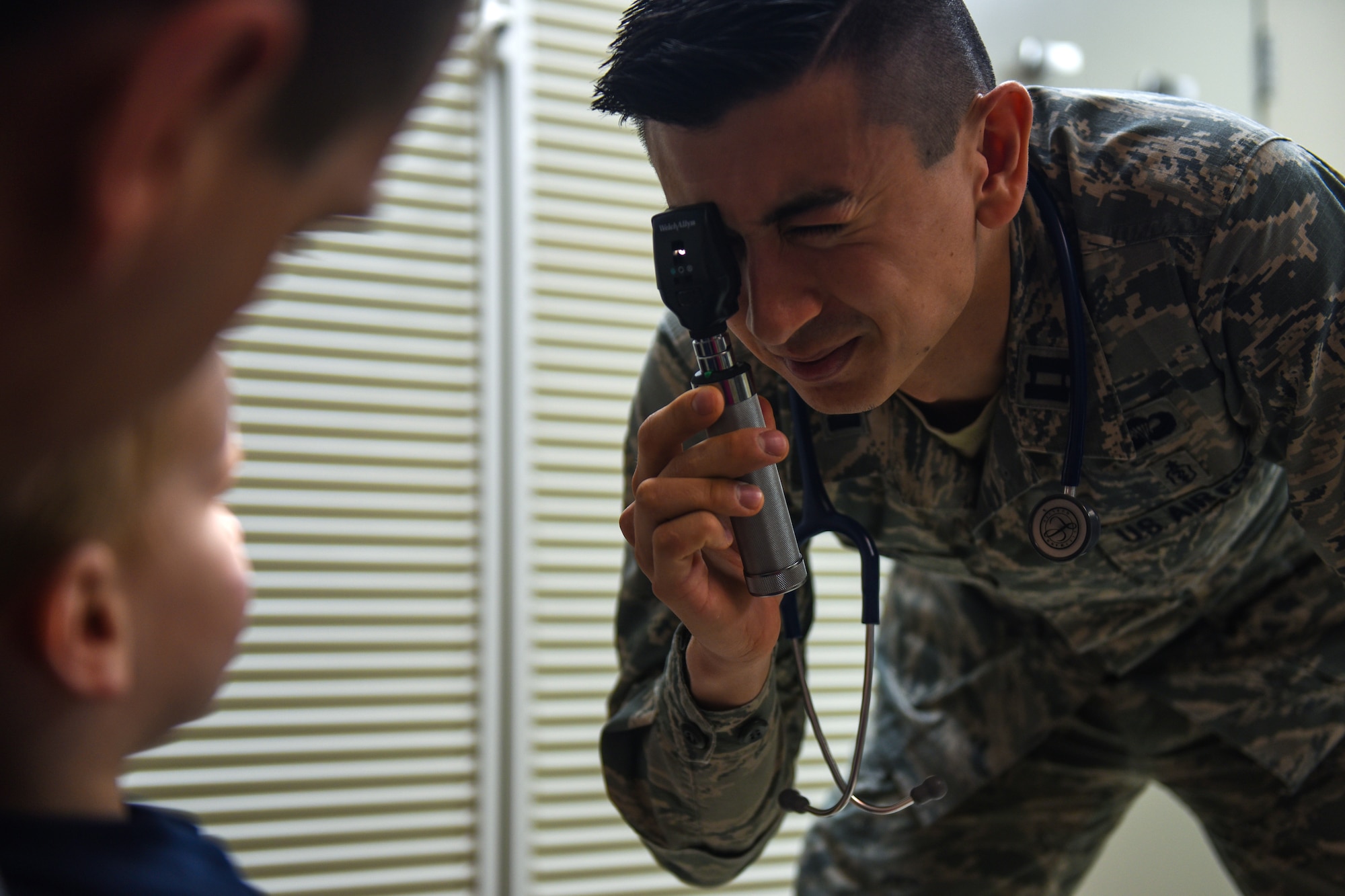 Capt. Joseph Migliuri, 92nd Medical Group pediatrician, performs a wellness vision exam during a patient’s check-up April 4, 2018, at Fairchild Air Force Base, Washington. The pediatric team has implemented a new concept of operations: rewarding, efficiency, setting priorities and empowering team members, or RESET, to their system of patient care. The integration of RESET in the Military Health System Genesis workflow has improved the clinic’s goals of patient access and care.  (U.S. Air Force photo/Airman 1st Class Whitney Laine)