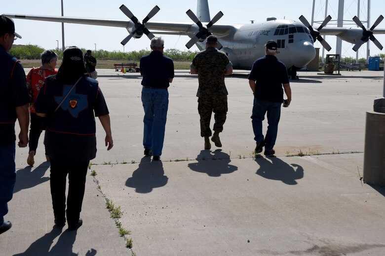 Members from the Texas chapter of the 3rd Marine Division Association walk towards their next stop on a tour of the Louis F. Garland Department of Defense Fire Academy on Goodfellow Air Force Base, Texas. The members were able to explore a training model C-130 Hercules used for practice by students going through the fire protection specialist courses at the fire academy. (U.S. Air Force photo by Airman 1st Class Seraiah Hines/Released)