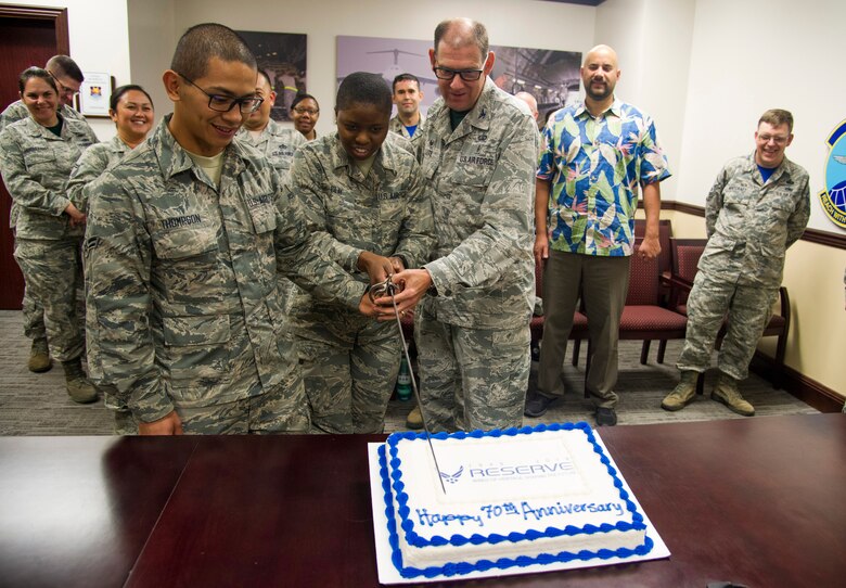 U.S. Air Force Col. Kenneth Lute, 624th Regional Support Group commander, along with Airman 1st Class Hamilton Thompson, left, and Airman Basic Deanna Clay kick off a 70th Air Force anniversary celebration with a cake-cutting event at Joint Base Pearl Harbor-Hickam, Hawaii, April 13.