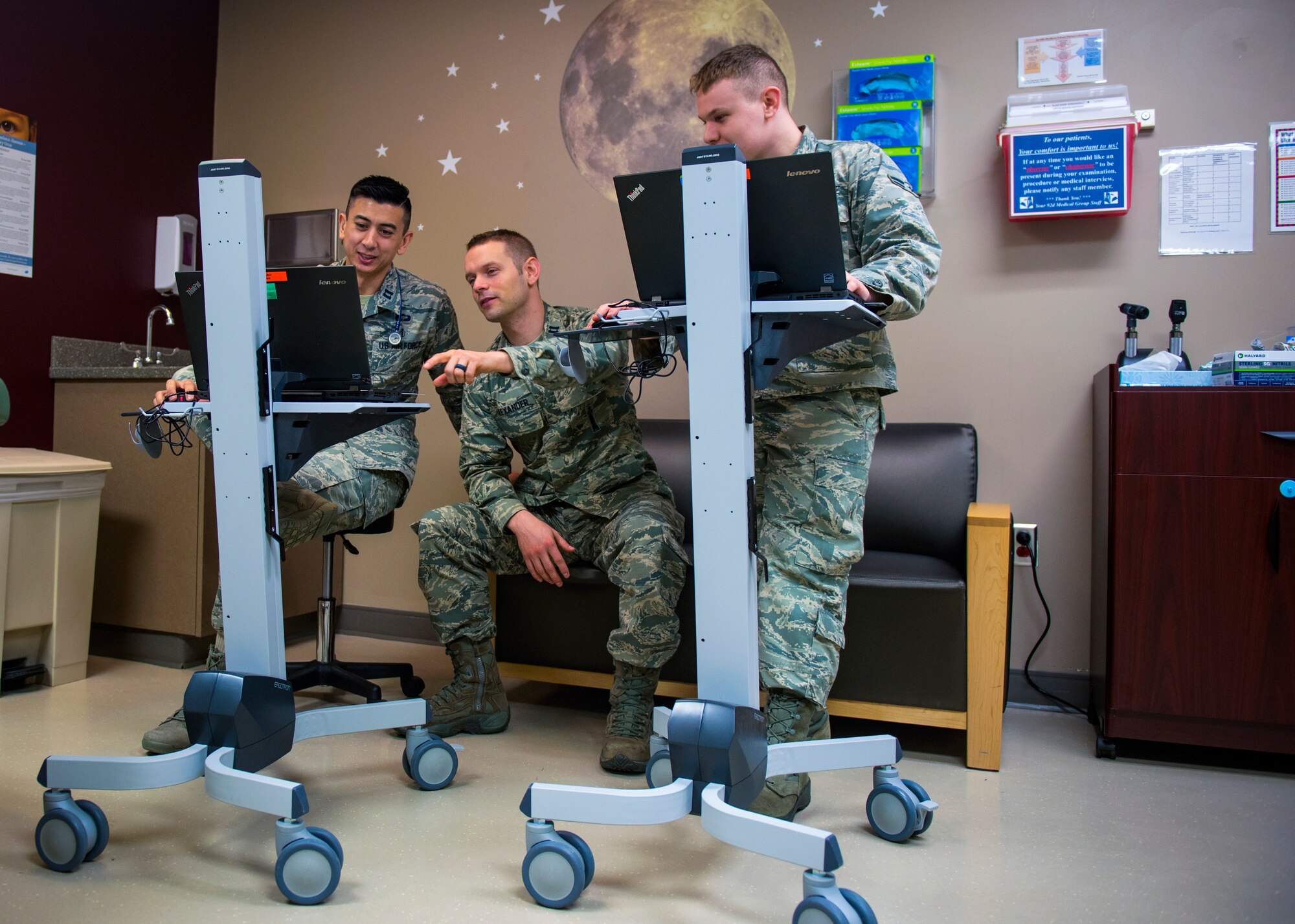 (from left) Capt. Joseph Migliuri, 92nd Medical Group pediatrician, Capt. Neal Alexander, 92nd MDG maternal child flight nurse manager, and Airman 1st Class Levi Brown, 92nd MDG aerospace medical technician, review patient medical records prior to an appointment at Fairchild Air Force Base, Wash., April 4, 2018. The pediatric team has implemented a new concept of operations: rewarding, efficiency, setting priorities and empowering team members, or RESET, to their system of patient care. Virtual appointments are offered to allow patients to receive the care they need from doctors without having to visit the clinic and has also allowed doctors to have more time to see more patients per day (U.S. Air Force photo by Airman 1st Class Whitney Laine)