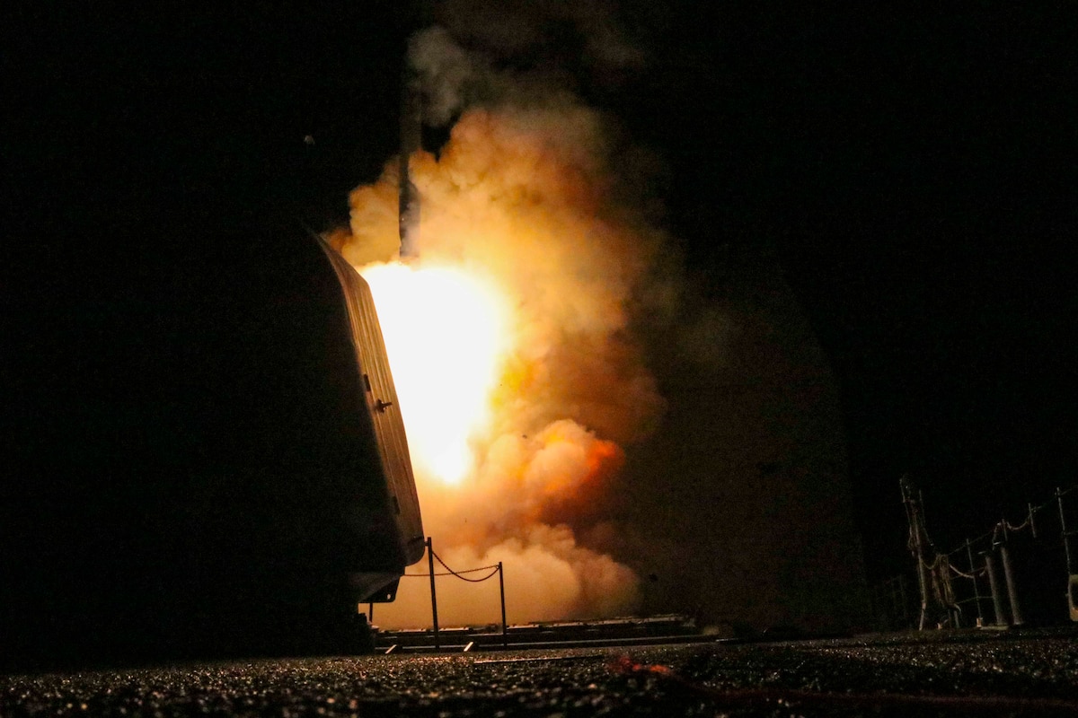 Flames erupt as a missile launches at night.