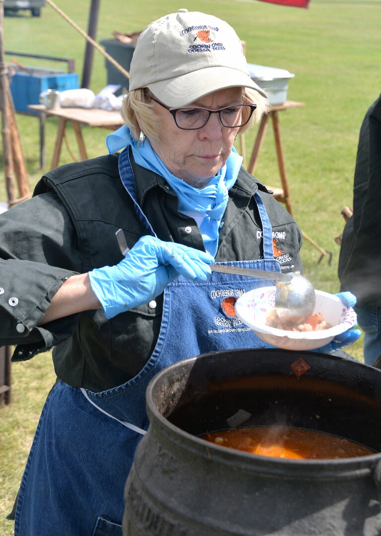 Susan Curry from the Cocklebur Camp chuckwagon out of Odessa, Texas, serves up some beef stew during the annual Cowboys and Heroes event held at MacArthur Parade Field at Joint Base San Antonio-Fort Sam Houston April 14.