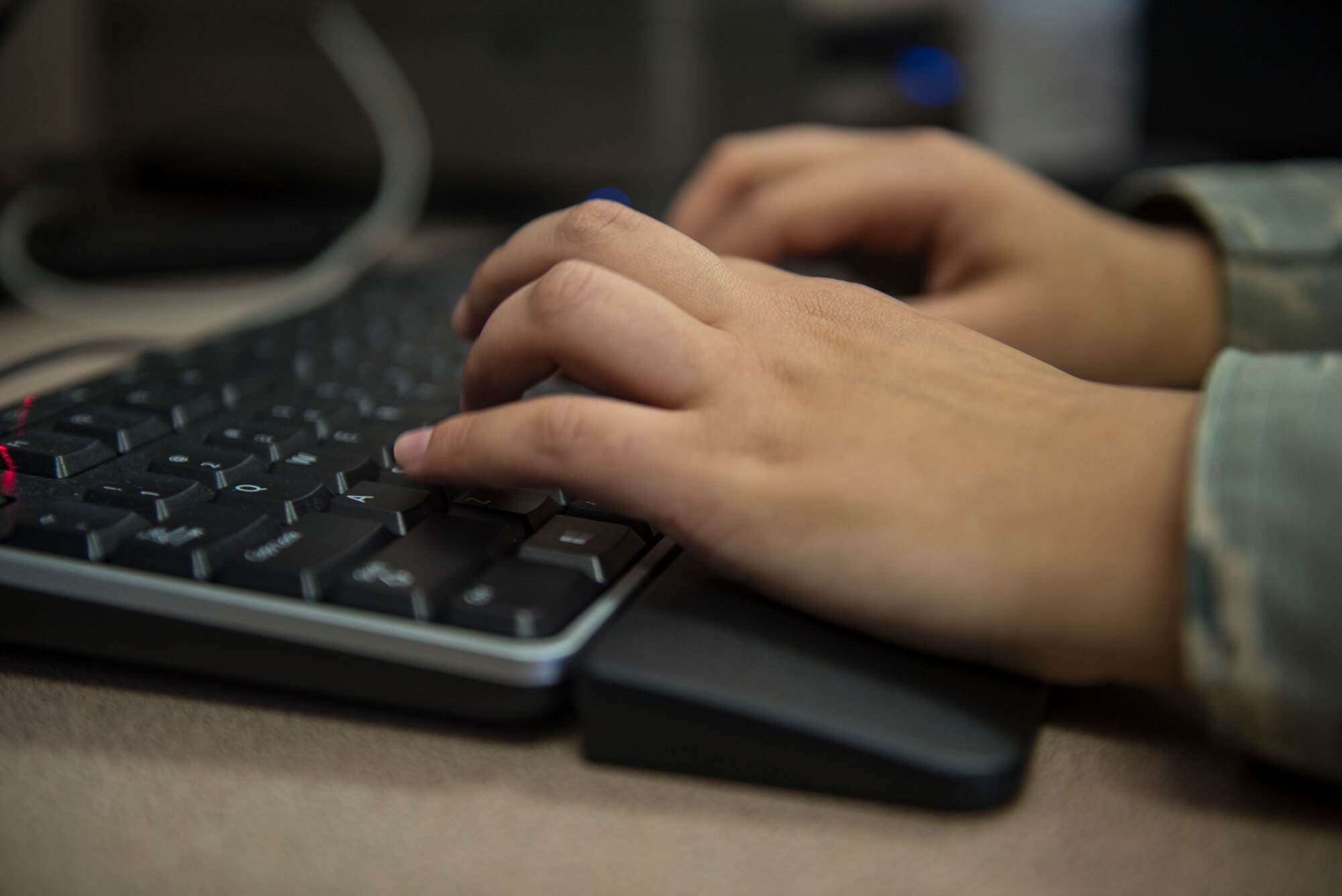 U.S. Air Force Airman 1st Class Leann Munoz, 18th Force Support Squadron customer service technician, types on a computer Mar. 29, 2018, at Kadena Air Base, Japan. The 18th FSS Military Personnel Section implemented a new process that enables customers to file for a dependent identification card from their cell phones or personal emails. Kadena is the 5th base to implement this new process. (U.S. Air Force photo by Staff Sgt. Micaiah Anthony)