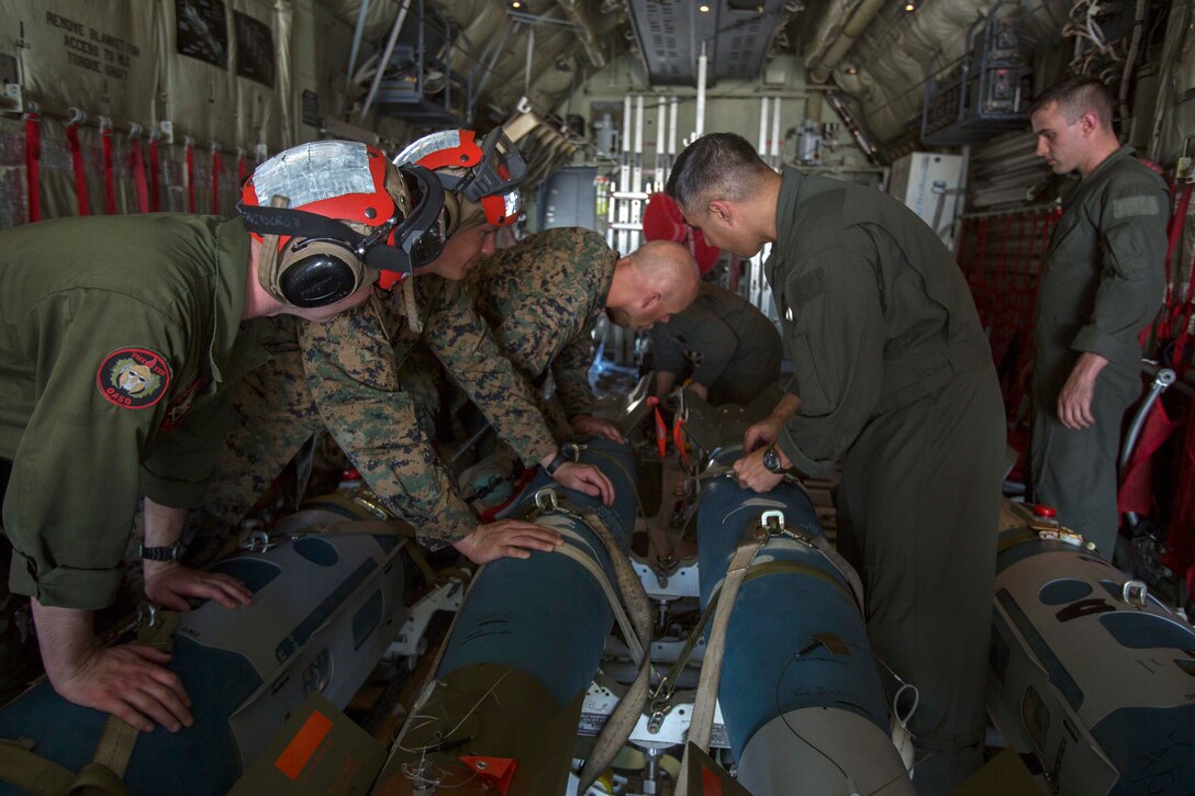 Marines secure bombs inside an aircraft.