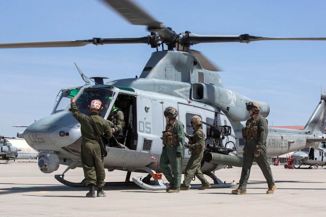 Marines prepare a UH-1Y Venom helicopter for takeoff.