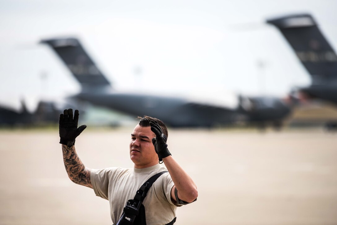 An airman demonstrates how to load a vehicle onto an aircraft.
