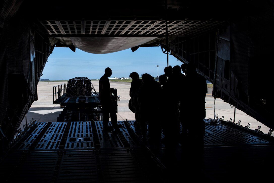 Squadron personnel demonstrate how to load a pallet onto an aircraft.