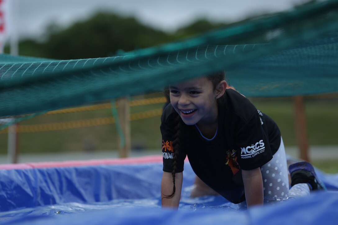 CAMP HANSEN, OKINAWA, Japan – A child crawls though a pool of water during the children’s 1k at the 2018 Camp Hansen World Famous Mud Run April 15 aboard Camp Hansen, Okinawa, Japan.