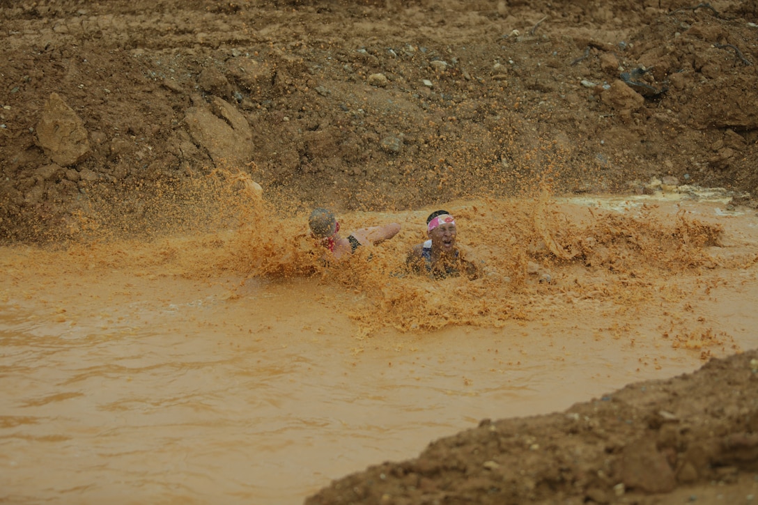 CAMP HANSEN, OKINAWA, Japan – Competitors splash into a pool of muddy water during the 2018 Camp Hansen World Famous Mud Run April 15 aboard Camp Hansen, Okinawa, Japan.