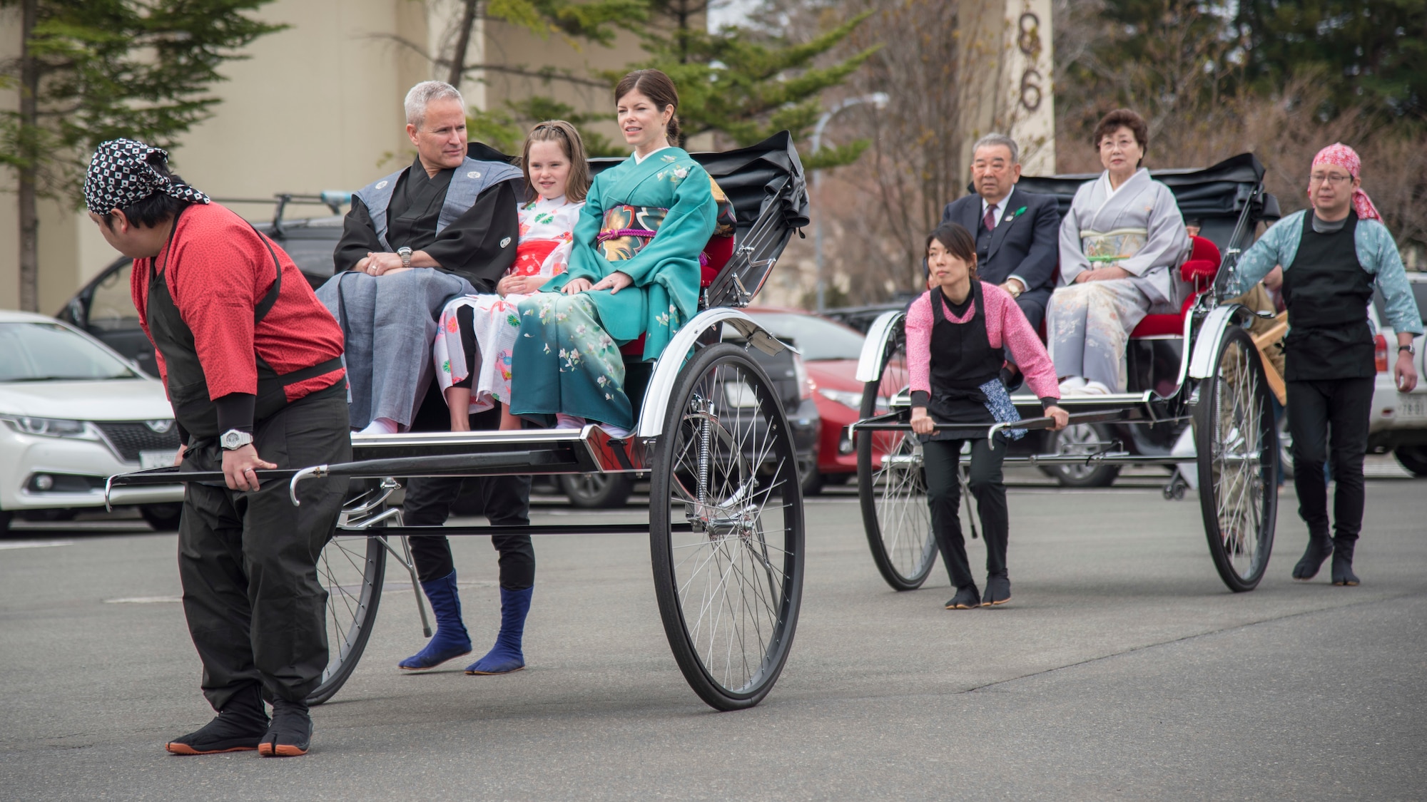 U.S. Air Force Col. Paul D Kirmis and his family, front, and Mayor Kazumasa Taneichi and wife, back, are escorted into the 31st Annual Japan Day at Misawa Air Base, Japan, April 14, 2018. These distinguished visitors held a ribbon cutting ceremony which represents the two cultures, one community concept. (U.S. Air Force photo by Airman 1st Class Collette Brooks).