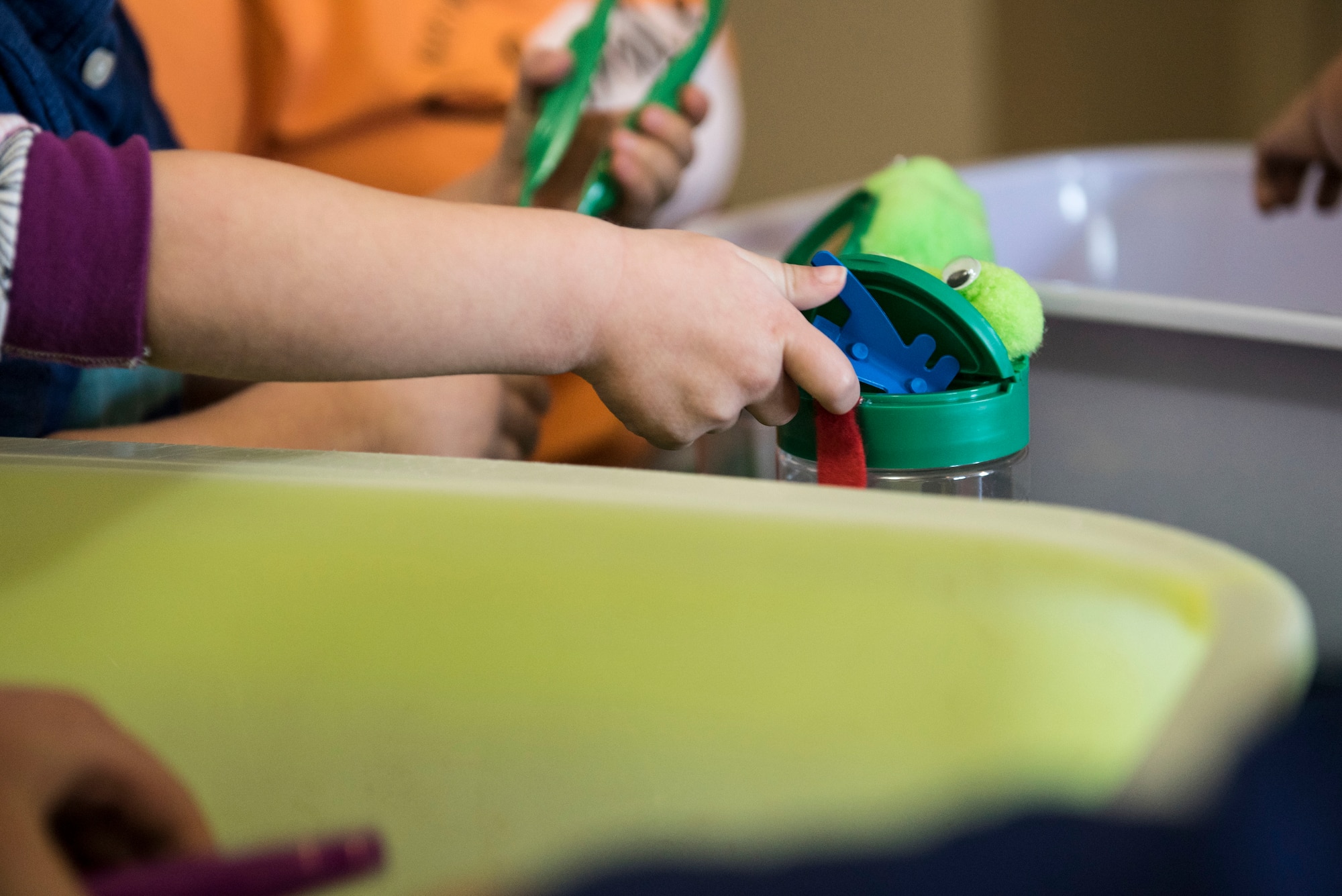 A child places a plastic bug inside a toy frog’s mouth during an activity at his Family Child Care (FCC) at Shaw Air Force Base, S.C., April 12, 2018.