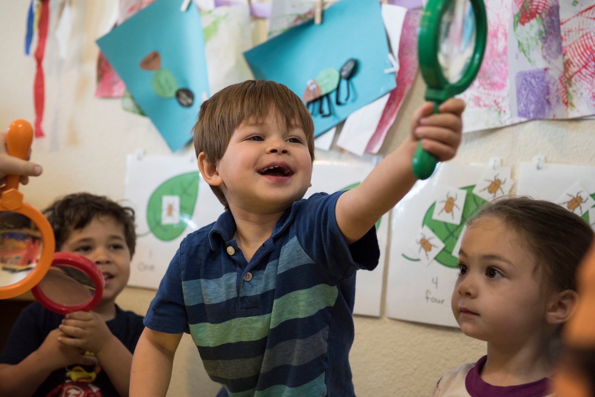 A child plays with a magnifying glass during an activity at a Family Child Care at Shaw Air Force Base, S.C., April 12, 2018.