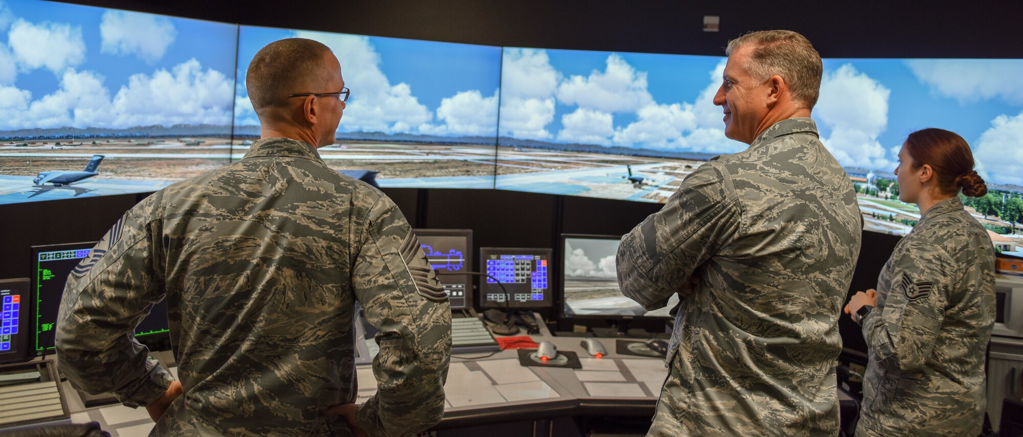 SSgt. Iiae Hess demonstrates the flight simulator for Col. Eaglin and Chief Daniels.