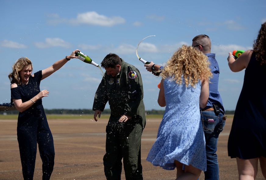 Lt. Col. Brent Green, 43rd FTS assistant director of operations, is sprayed with champagne and water by his family April 13, 2018, on Columbus Air Force Base, Mississippi. He is one of the original cadre in the Firebirds. It was shortly after the squadron expanded in 1999 from teaching only in the T-38C Talon to teaching all airframes that he was hired. Green has spent 22 years of his career in a full-time capacity learning or teaching in the T-37, T-38 and T-6A Texan II on Columbus AFB. (U.S. Air Force photo by Airman 1st Class Keith Holcomb)