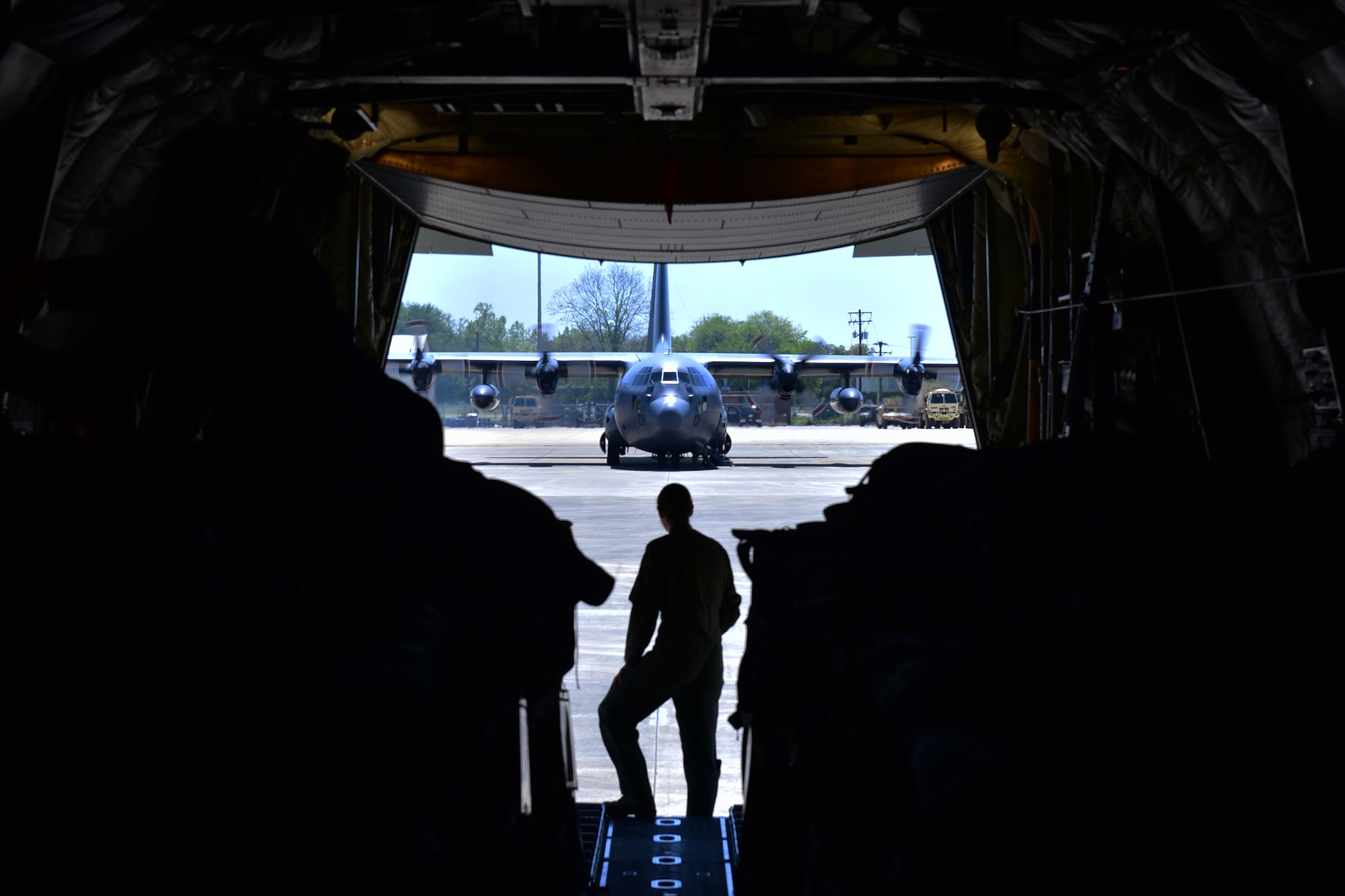 Woman looks at C-130 from back of C-130J.