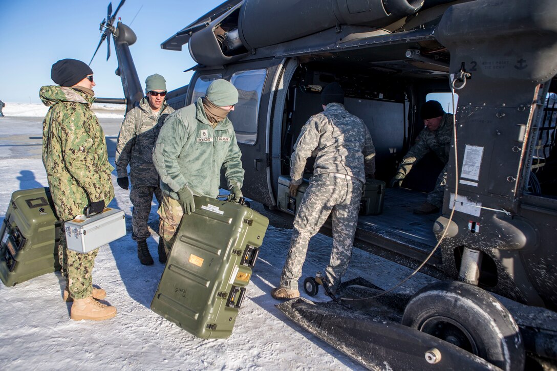 Service members load a U.S. Army UH-60 Black Hawk helicopter with gear and supplies in support of Innovative Readiness Training Arctic Care 2018, as they prepare to depart Kotzebue, Alaska, and travel to outlying villages, April 14, 2018. Service members in support of IRT Arctic Care will conduct critical mission training and logistical movements in order to simulate military/civilian humanitarian operations and health care delivery in time of crisis, conflict or disaster. (U.S. Marine Corps photo by Lance Cpl. Ricardo Davila)