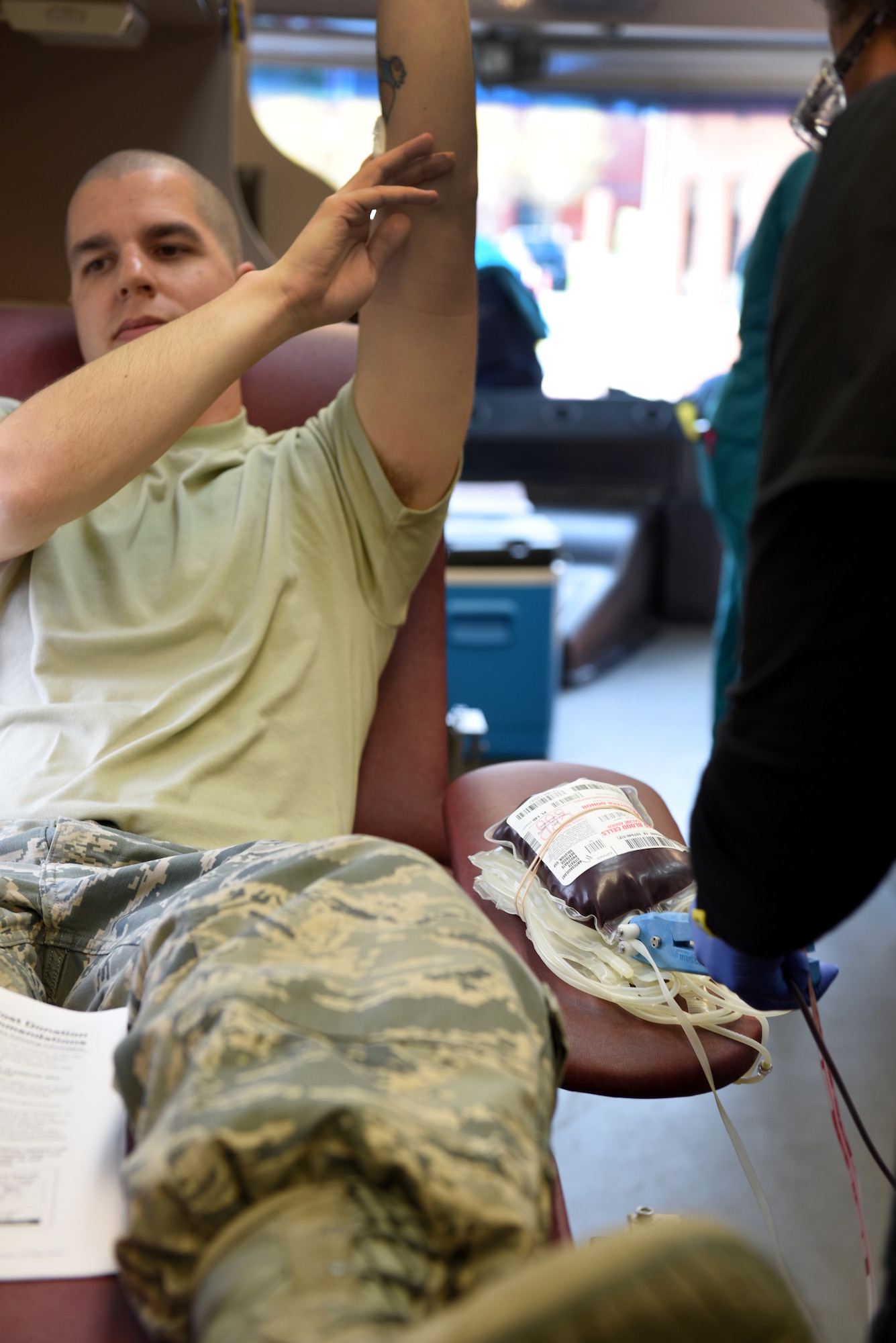 U.S. Air Force Staff Sgt. Bradley Onley, 145th Communications Squadron information technician (left), raises his arm to distribute blood flow while Crystal Dorsey (right), donor services technician with the Community Blood Center of the Carolinas (CBCC), gathers his blood donation pint in a mobile unit at the North Carolina Air National Guard (NCANG) Base, Charlotte Douglas International Airport, April 8, 2018. The CBCC has visited the base for the last four consecutive years collecting pints of blood for patients in need across North and South Carolina. (U.S. Air Force photo by Staff Sgt. Laura J. Montgomery/)