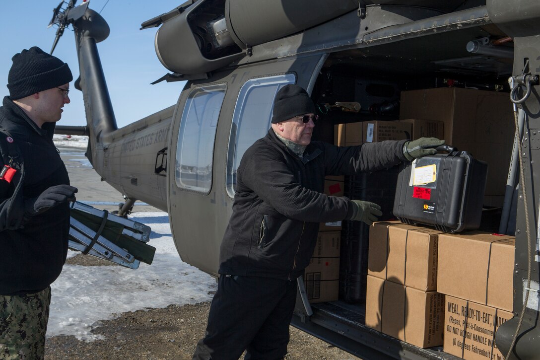 Participants with Innovative Readiness Training Arctic Care 2018 load a U.S. Army UH-60 Black Hawk helicopter with gear and supplies as they prepare to depart Kotzebue, Alaska, and travel to outlying villages, April 13, 2018.