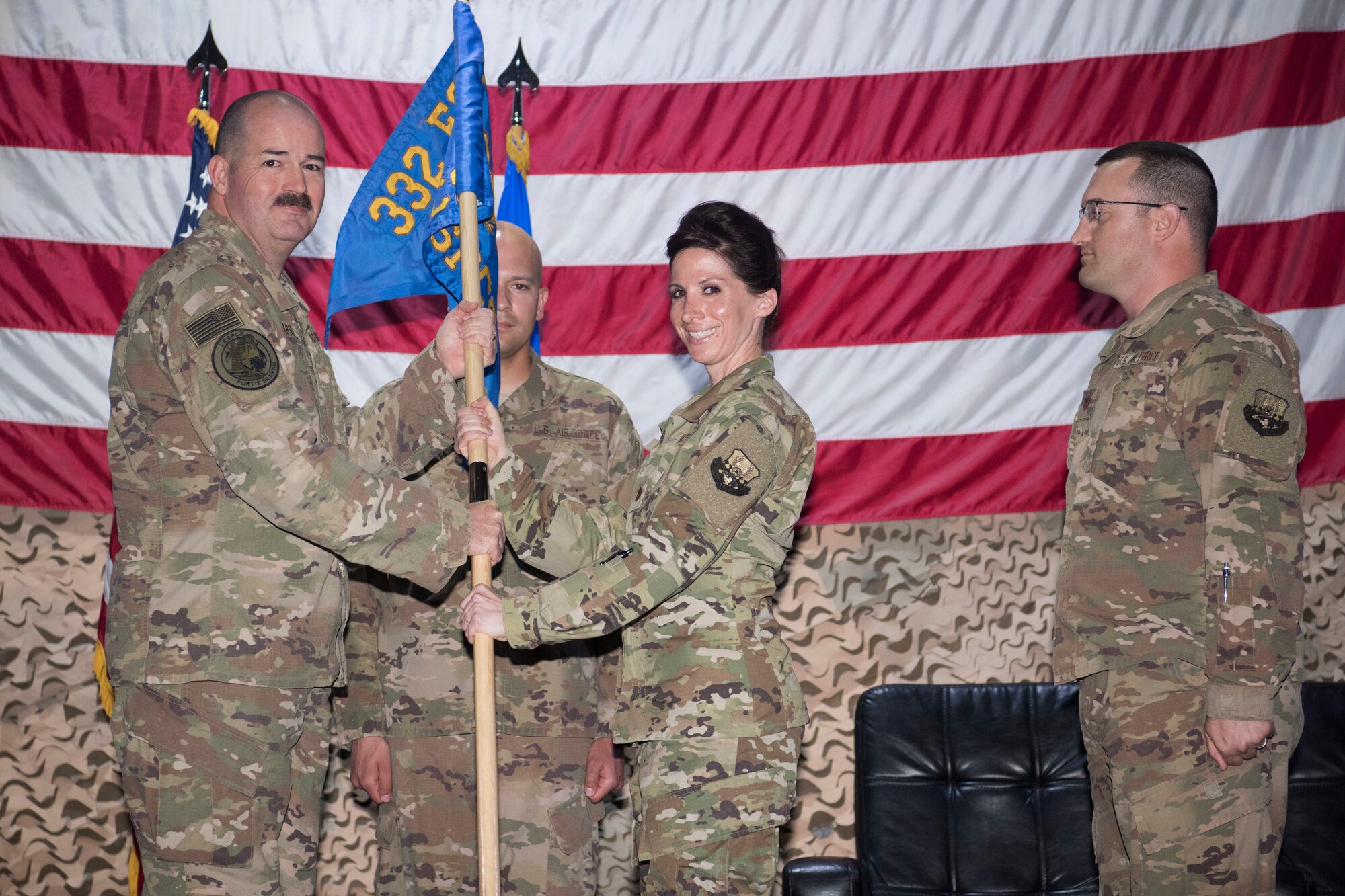 Maj. Cassandra Devolites, 1st Expeditionary Space Control Squadron incoming commander, accepts the unit guideon from Col. William Marshall, Expeditionary Operations Group commander, as Maj. Stephen Ziegenfuss, 1st ESPCS outgoing commander, watches on April 8, 2018, at an undisclosed location in Southwest Asia.