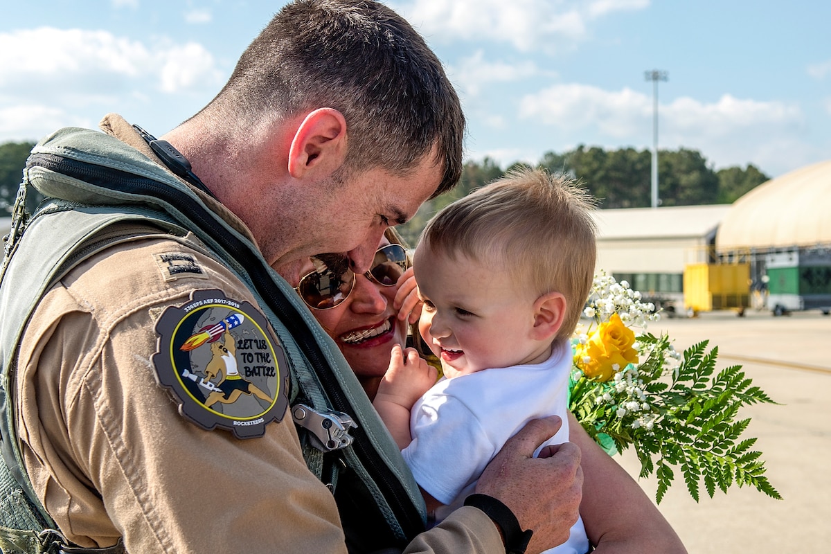 An airman holds a small child.
