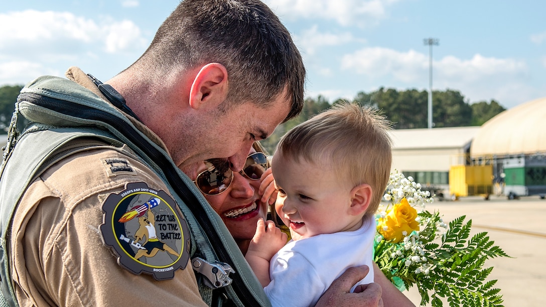 An airman holds a small child.