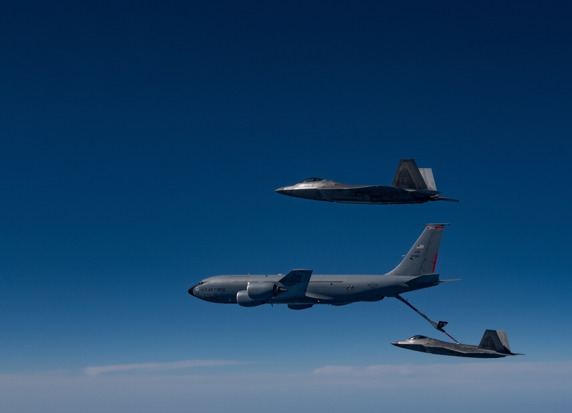 A KC-135 Stratotanker from the 121st Air Refueling Wing refuels F-22 Raptors from the 94th Fighter Squadron and 27th Fighter Squadron over the Atlantic Ocean, April 12, 2018. The 94th FS and 27th FS are the fighter squadrons of the 1st Fighter Wing at Joint Base Langley-Eustis, Va. and the 121st ARW is from Rickenbacker Air National Guard Base, Ohio. (U.S. Air Force photo by Staff Sgt. Carlin Leslie)