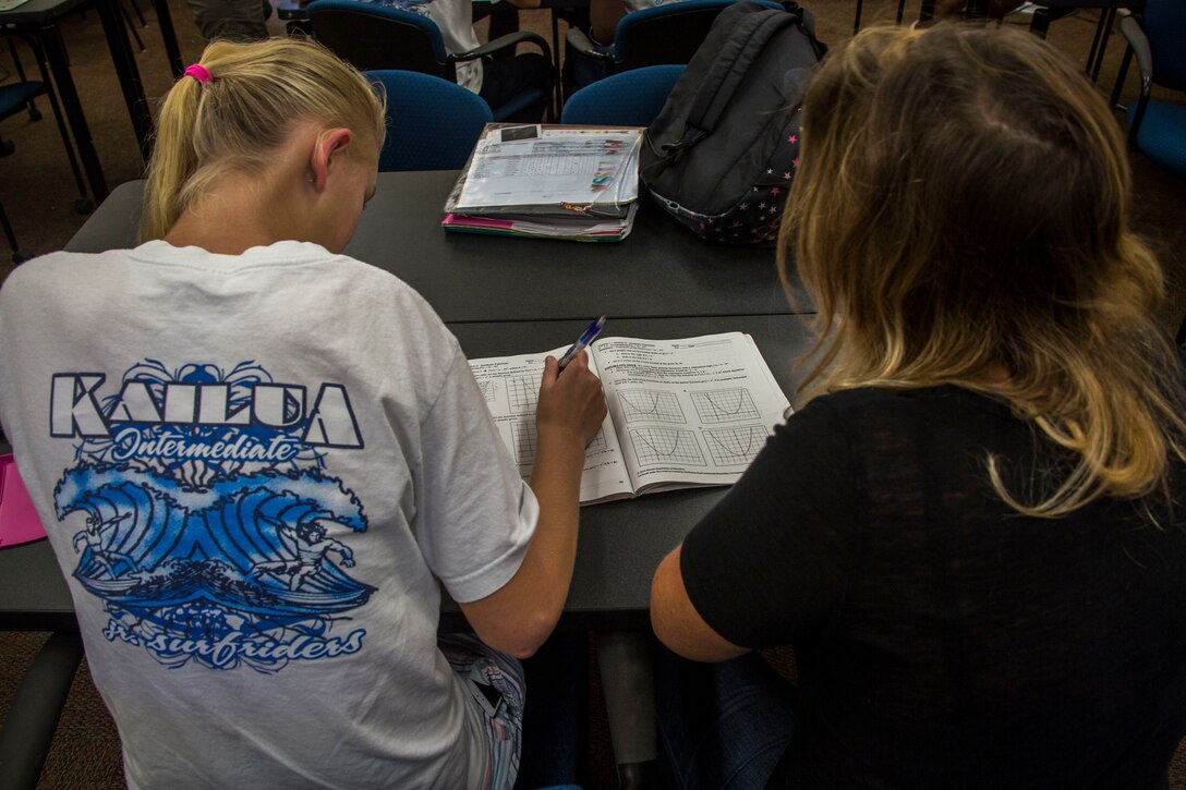 Devanne Parent, an algebra one teacher from Kailua Intermediate School (KIS), assists a student from KIS with homework during a “Counting on Math” tutoring session at the Education Center, Marine Corps Base Hawaii, April 12, 2018. The Count on Math tutoring program focuses on helping students with their mathematics skills while also exploring other subjects. (U.S. Marine Corps photo by Lance Cpl. Matthew Kirk)