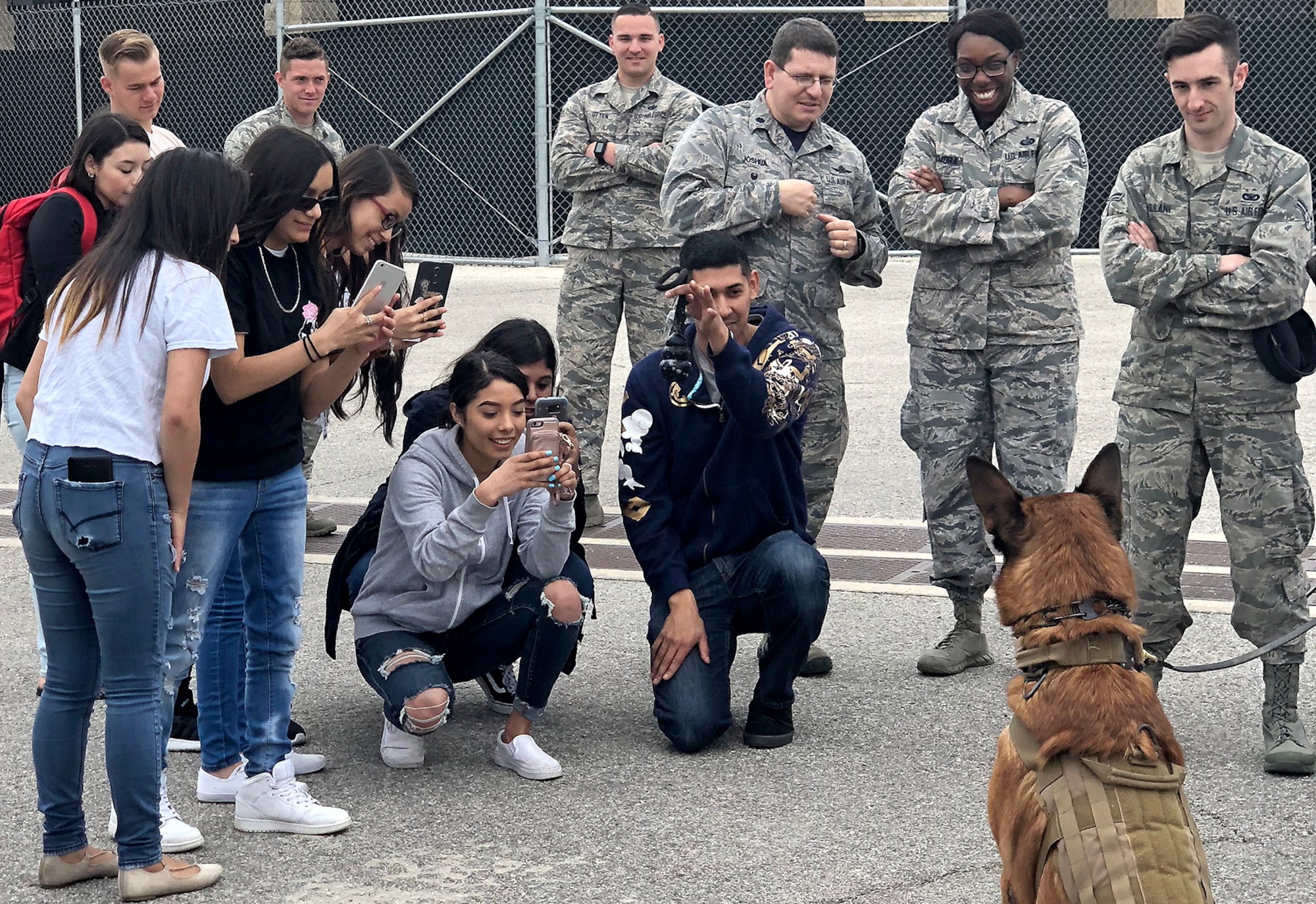 South San Antonio High School students take pictures of Balto, an 802nd Security Forces Squadron military working dog, during a Troops for Teens event at Joint Base San Antonio-Lackland, Texas, March 9, 2018. Troops for Teens, a joint SSAHS and Air Forces Cyber volunteer program, links Airmen mentors with teens. (U.S. Air Force photo by Tech. Sgt. Jamie Adimora)