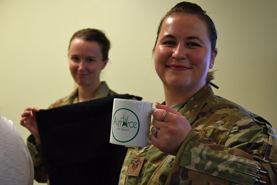 U.S. Air Force Airman 1st Class Crystal Kessler, U.S. Air Forces Central Command (AFCENT) admin, left, and Staff. Sgt. Anastasia Rash, AFCENT communications systems planner, hold promotional items they received during a Sexual Assault Prevention and Response (SAPR) office open house at Shaw Air Force Base, S.C., April 12, 2018.