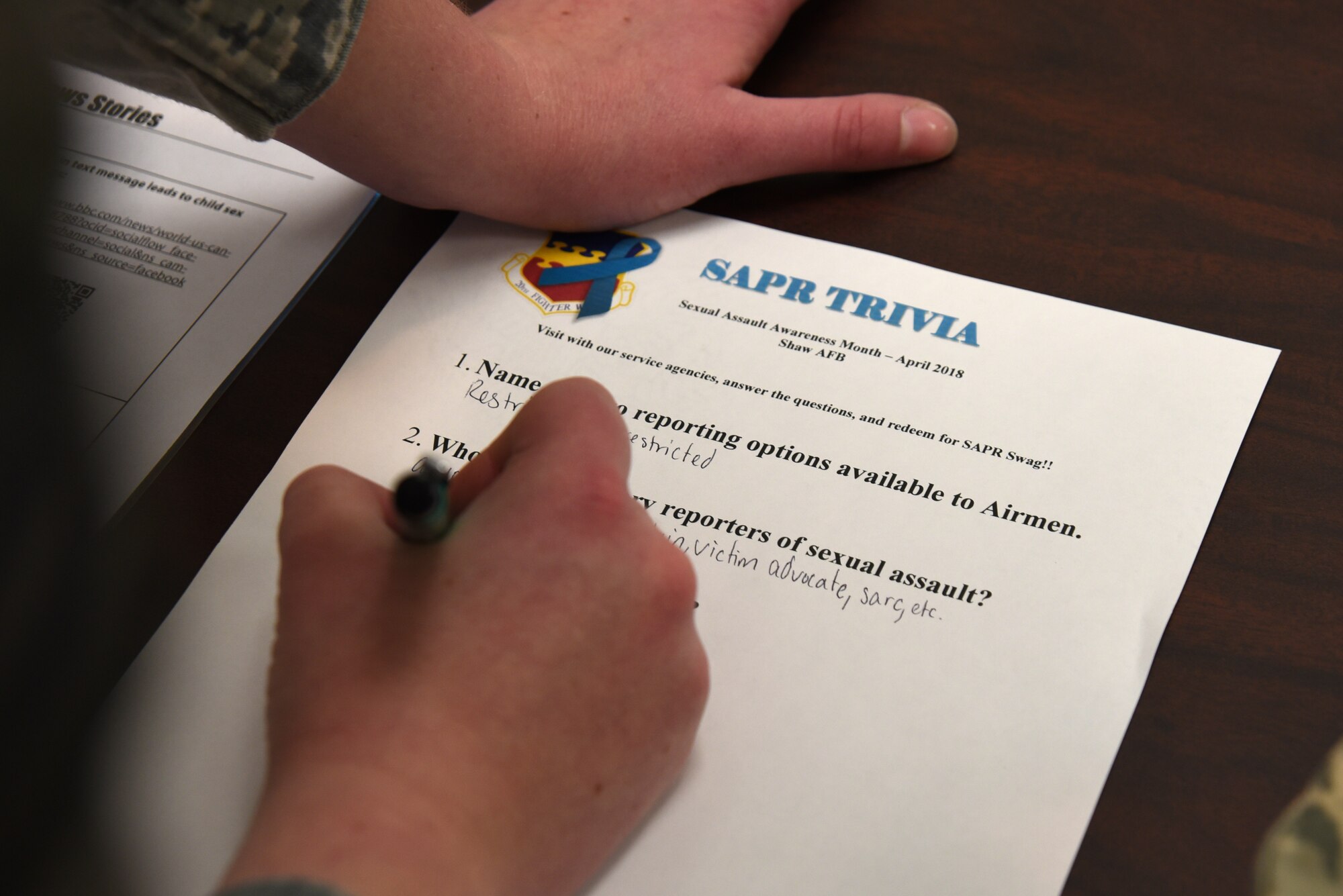 U.S. Air Force Senior Airman Kelsey Tucker, 20th Fighter Wing Public Affairs photojournalist, answers Sexual Assault Prevention and Response (SAPR) trivia questions during a SAPR office open house at Shaw Air Force Base, S.C., April 12, 2018.