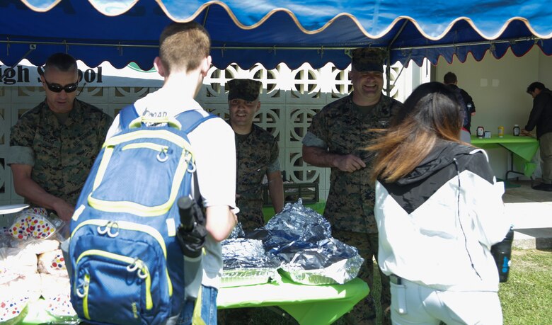 CAMP FOSTER, OKINAWA, Japan – Marine Corps senior leadership serve food to students during the Kubasaki High School Month of the Military Child barbecue April 10 aboard Camp Foster, Okinawa, Japan.