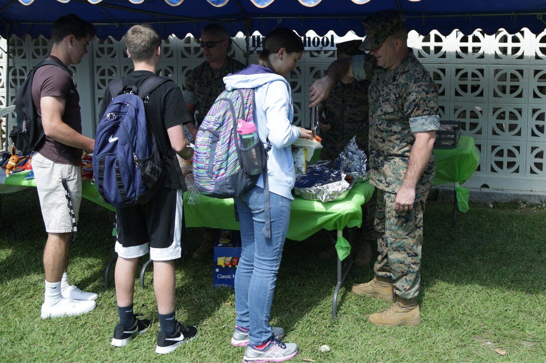 CAMP FOSTER, OKINAWA, Japan – Marine Corps senior leadership serve students food during the Kubasaki High School Month of the Military Child barbecue April 10 aboard Camp Foster, Okinawa, Japan.