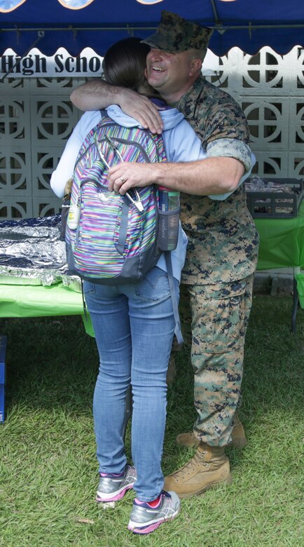 CAMP FOSTER, OKINAWA, Japan – Sgt. Maj. Daniel West hugs his daughter during the Kubasaki High School Month of the Military Child barbecue April 10  aboard Camp Foster, Okinawa, Japan.