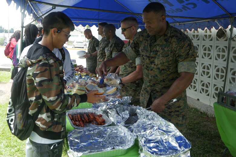 CAMP FOSTER, OKINAWA, Japan – Marine Corps senior leadership serve students lunch during the Kubasaki High School Month of the Military Child barbecue April 10 aboard Camp Foster, Okinawa, Japan.