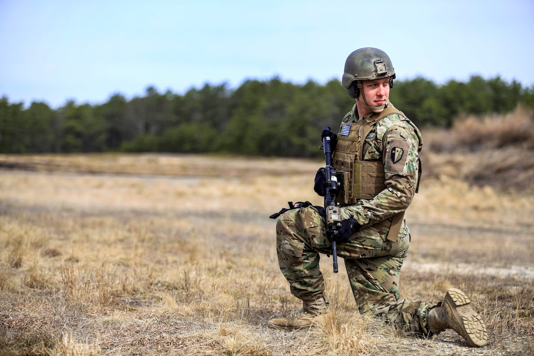 A soldier takes a knee while awaiting follow-on orders.