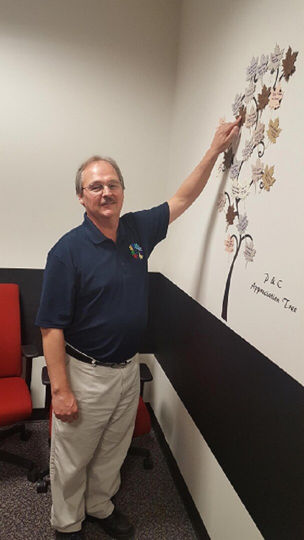 Jay Hilderbran places his leaf for "Excellence in Organization" on the Tree of Appreciation.