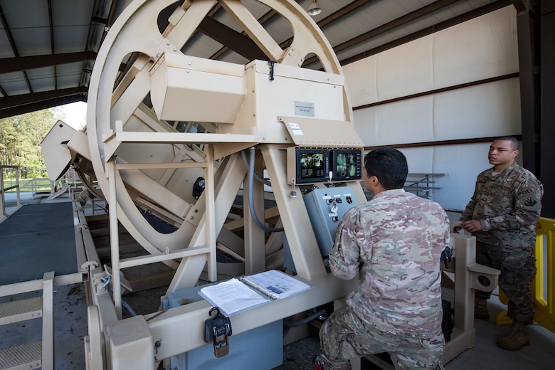 Staff Sgt. Ulysses Ortiz, 820th Combat Operations Squadron unit trainer, left, operates a mine-resistant, ambush-protected (MRAP) vehicle roll-over simulator during an Emerge Moody tour, April 12, 2018, at Moody Air Force Base, Ga. Emerge Moody is a program in which select Airmen and civilians tour various units to gain a better understanding of the installations overall mission, capabilities and comprehensive duties. During their tour of the 820th Base Defense Group, Emerge Moody members observed and participated in various demonstrations such as a MRAP rollover simulator, full-mission brief, a sniper display and a tactical gear and static vehicle presentation. (U.S. Air Force photo by Airman 1st Class Eugene Oliver)