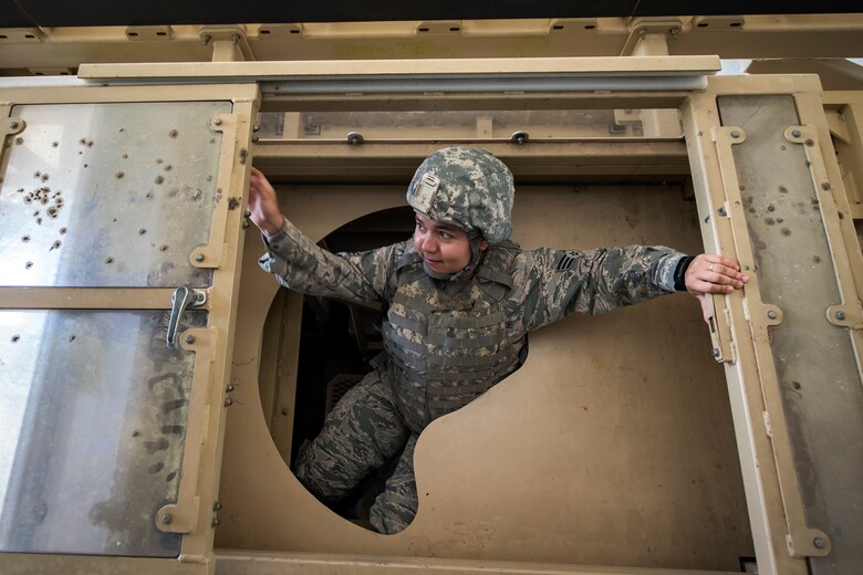 Senior Airman Andrea Rojas-Jimenez, 23d Communications Squadron knowledge manager, climbs out of the top door of a mine-resistant, ambush-protected (MRAP) vehicle roll-over simulator during an Emerge Moody tour, April 12, 2018, at Moody Air Force Base, Ga. Emerge Moody is a program in which select Airmen and civilians tour various units to gain a better understanding of the installations overall mission, capabilities and comprehensive duties. During their tour of the 820th Base Defense Group, Emerge Moody members observed and participated in various demonstrations such as a MRAP rollover simulator, full-mission brief, a sniper display and a tactical gear and static vehicle presentation. (U.S. Air Force photo by Airman 1st Class Eugene Oliver)