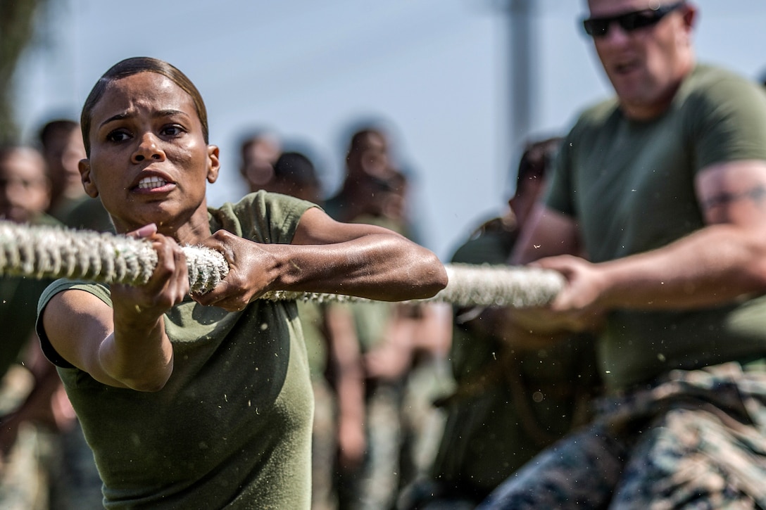 Two Marines pull on a rope during tug-of-war.