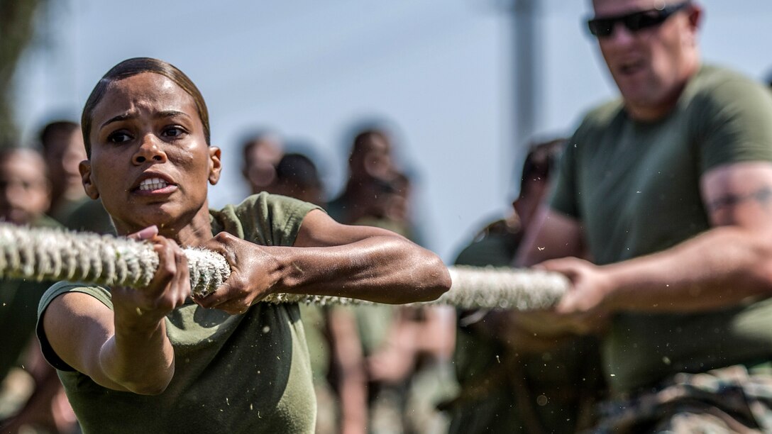 Two Marines pull on a rope during tug-of-war.